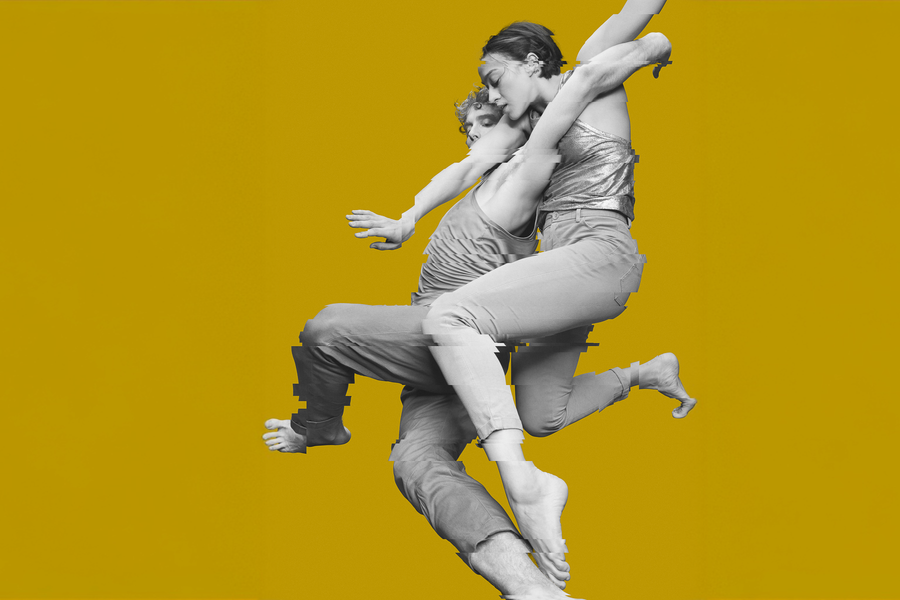 Twee dansers verstrengeld en gefotografeerd in zwart wit tegen een oker achtergrond