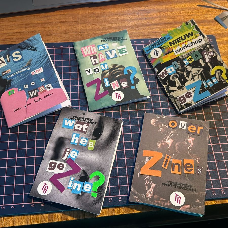 Een foto van een tafel met daarop een snijmat en andere knutselspullen en daarop vijf zelfgemaakte magazines