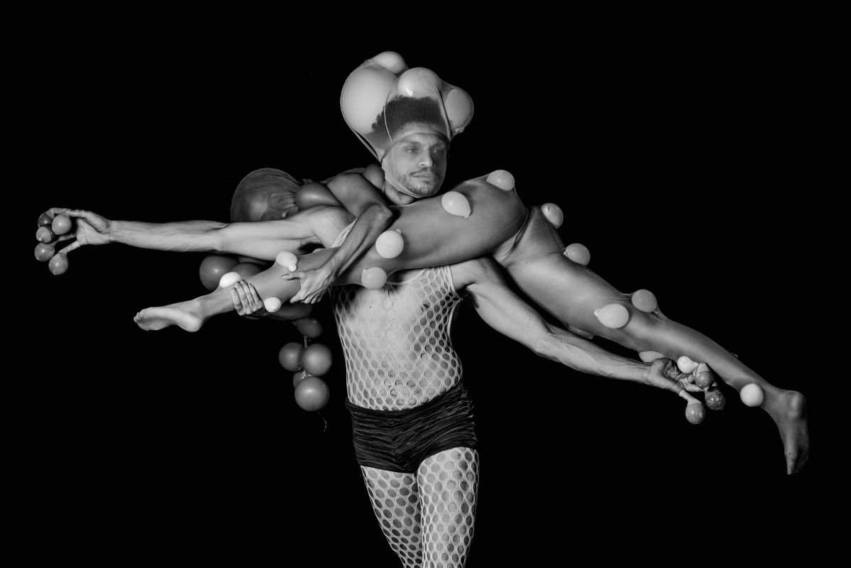 Een dansers tilt een andere danser  in het rond op zijn nek.