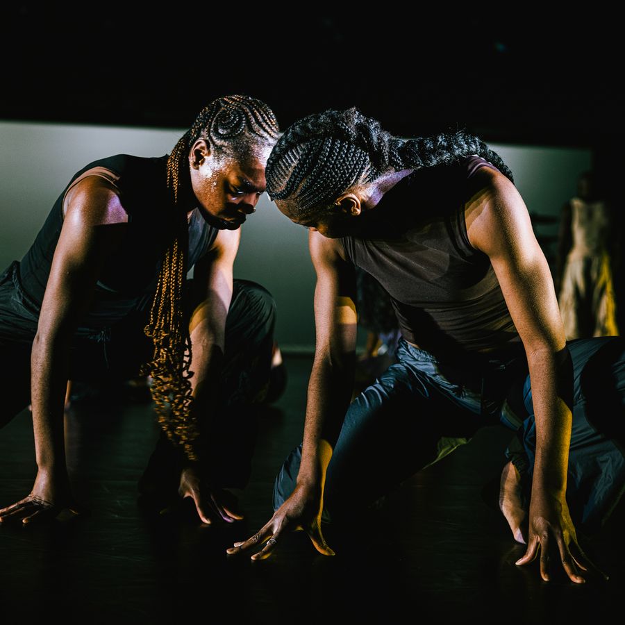Scènefoto uit de voorstelling Closed Eyes, dansers en tweelingzussen Nathalie en Doris Bokongo Nkumu zittend op handen en knieën.