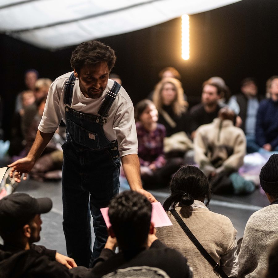 Theatermaker Fariborz Karimi temidden van het publiek van zijn eigen voorstelling
