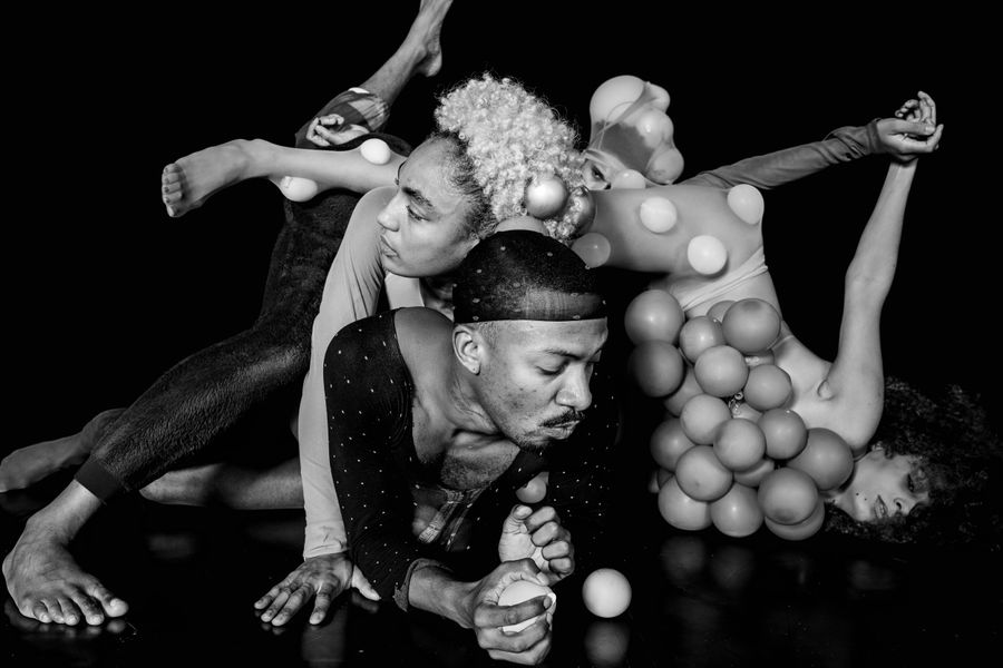 Drie danser rollen over de grond.