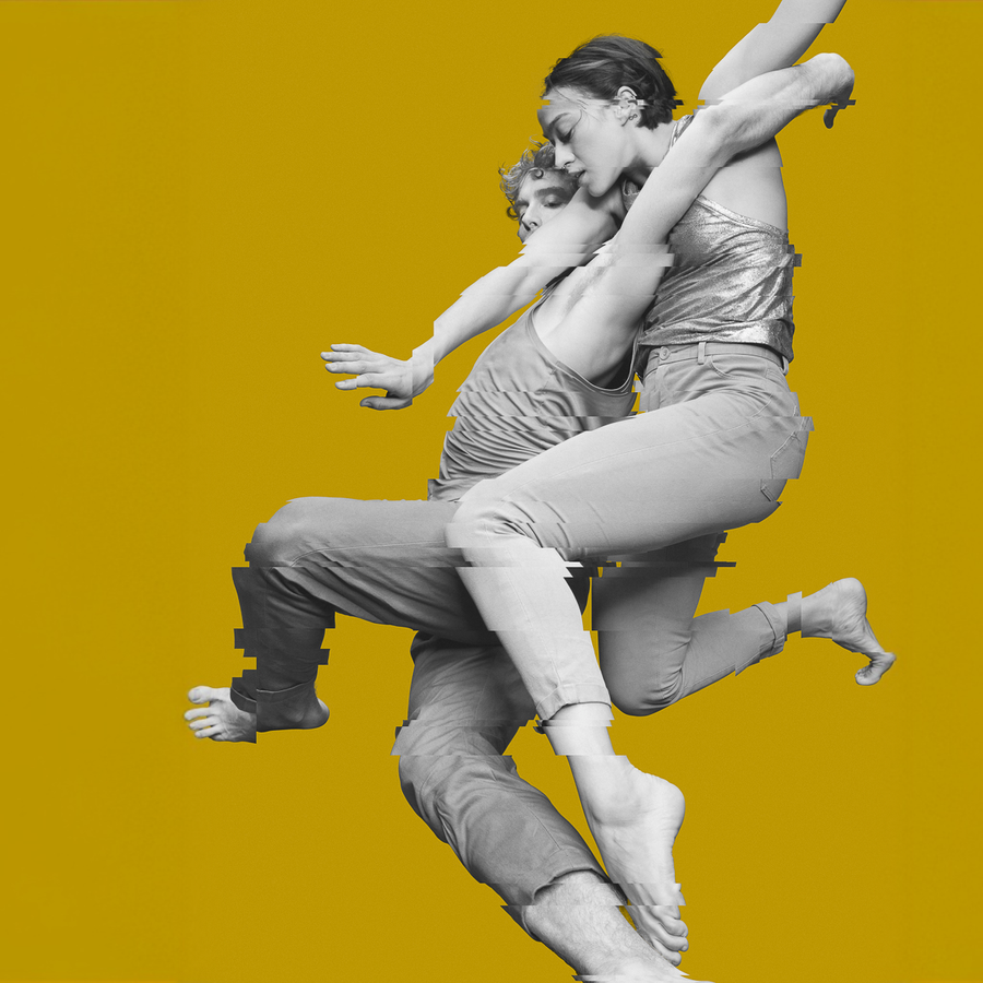 Twee dansers verstrengeld en gefotografeerd in zwart wit tegen een oker achtergrond